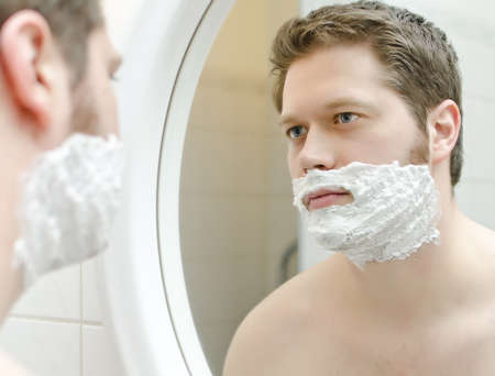 Man preparing to shave, foam on faceの写真素材