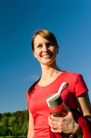 Smiling female runner with bottle of waterの写真素材
