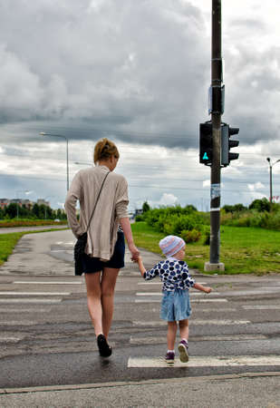 Mother and little daughter on zebra crossingの写真素材