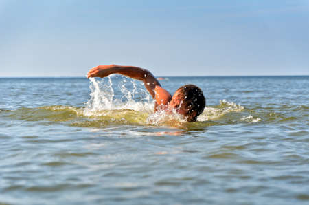 Young male swimming in the sea/oceanの写真素材