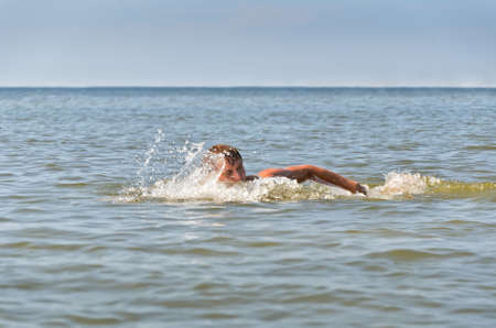 Young male swimming in the sea/oceanの写真素材