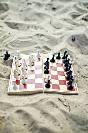 Chessboard with figures on it on the sandの写真素材