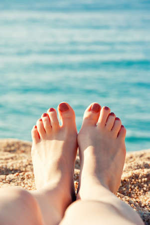 Close up female feet at sandy beachの写真素材
