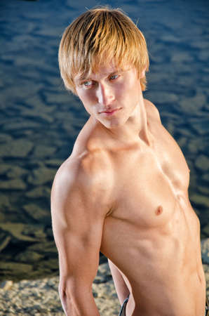 Portrait of handsome man posing near waterの写真素材