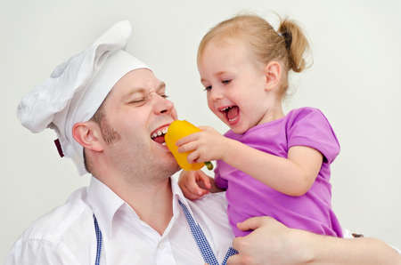 Little girl and her father having fun in the kitchenの写真素材