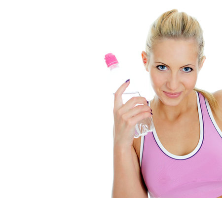 Pretty young female fitness trainer with bottle of water. Isolated on white