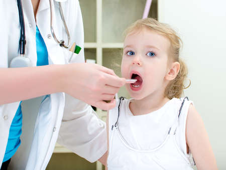 Cute little girl visiting pediatrician and taking medicineの写真素材