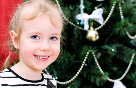 Portrait of a cute little girl on christmas backgroundの写真素材