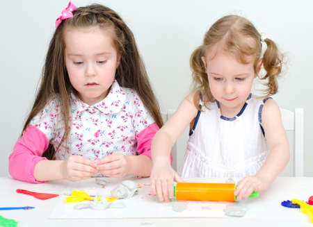 Two little girls sculpting using clayの写真素材