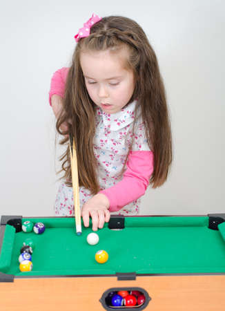 Cute little girl playing mini billiardの写真素材