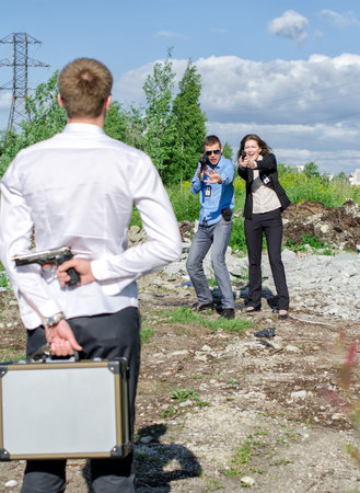 Two FBI agents conduct arrest of an offender with the gunの写真素材