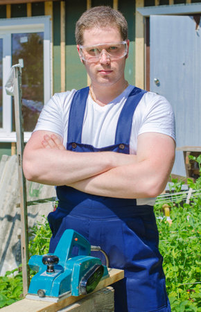 Handyman using electric planer outdoors
