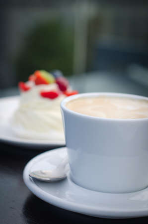 Coffee cup and creamy cake with berriesの写真素材