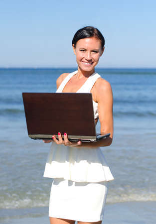 Attractive woman with notebook on the beachの写真素材