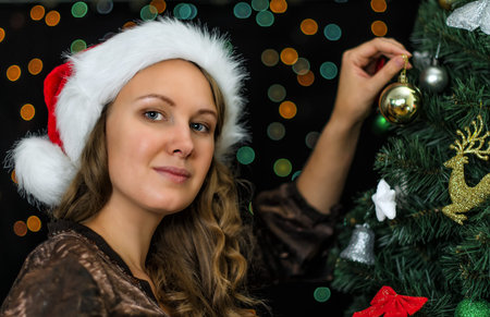 Attractive woman decorates the Christmas tree