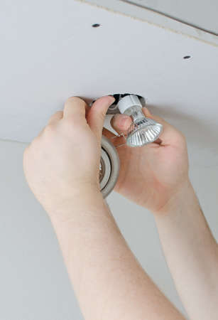Male hands installing light bulbの写真素材