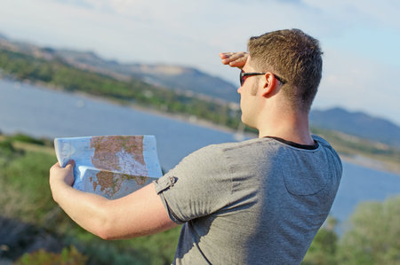 Male tourist with map on vacation. From the back.
