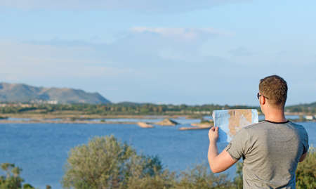 Male tourist with map on vacation. From the back.の写真素材