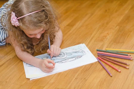 Little girl drawing car with colored pencils の写真素材