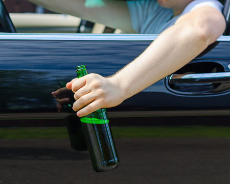 Driving Under the Influence  Male hand with bottle of beer 
