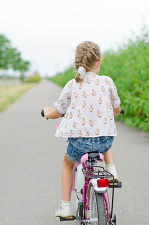 Little girl riding a bicycle in the park の写真素材