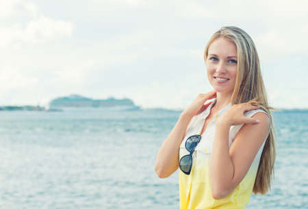 Beautiful young woman posing near the sea の写真素材