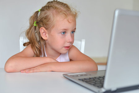 Little girl watching cartoons at computer.