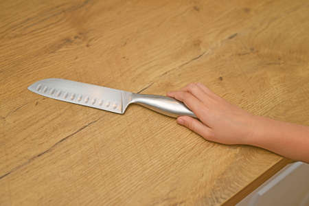 Dangerous situation in the kitchen. Child is trying to get a kitchen knife.の写真素材