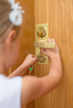 Little girl opening door to someone の写真素材