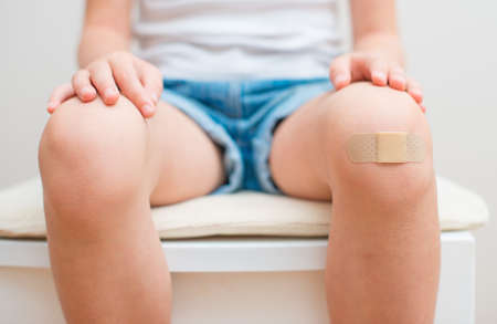 Child knee with an adhesive bandage の写真素材