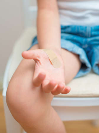 Child hand with an adhesive bandage の写真素材