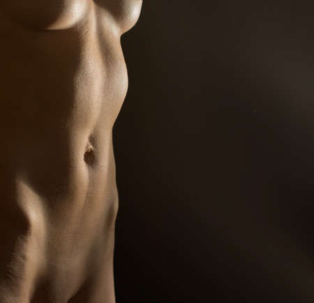 Sexy unrecognizable woman body on black background.    の写真素材