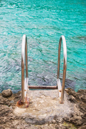 Handrails mounted on rock near the sea.の写真素材