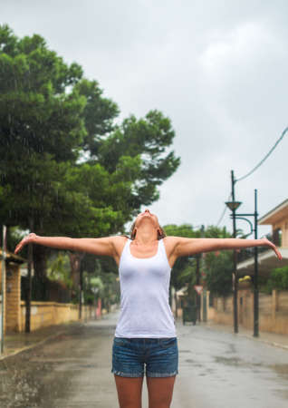 Happy blonde woman enjoying tropical rain.の写真素材