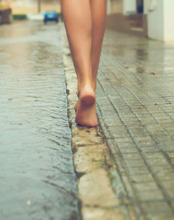 Woman having fun on the street after the rain.の写真素材