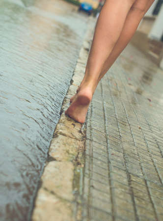 Woman having fun on the street after the rain.の写真素材