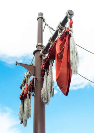 Old sailing ship masts with red sails.の写真素材