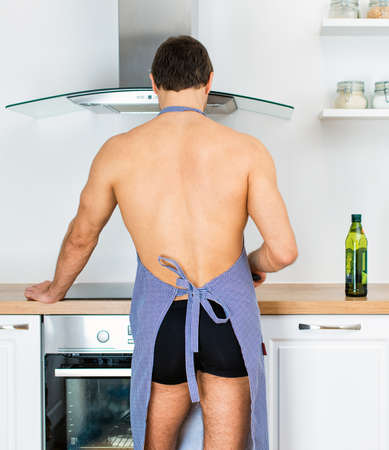 Man preparing food in the kitchen. View from the back.の写真素材