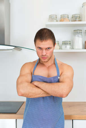 Man wearing apron in the kitchen.の写真素材