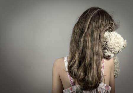 Little girl crying in the corner. Domestic violence concept.の写真素材