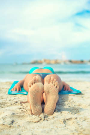 Woman sunbathing on sand. Place for text.の写真素材