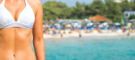 Part of suntanned woman body against beach.の写真素材