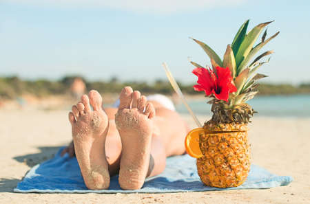 Woman with cocktail sunbathing on the beach vacation.の写真素材