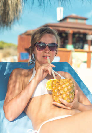 Woman with cocktail on the beach vacation.の写真素材