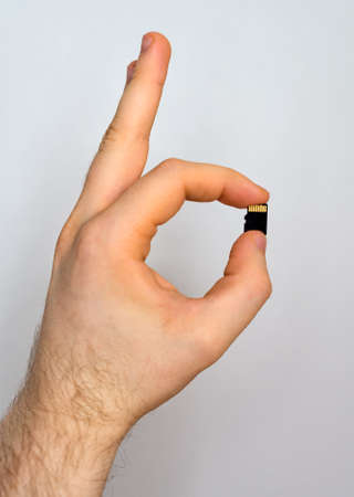 Male hand holding Micro SD card.の写真素材