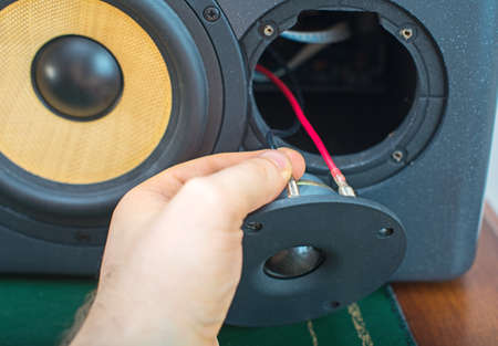 Male hand connecting professional studio monitor speaker.の写真素材