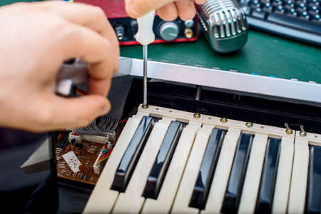Male hand fixing midi keyboard controller.の写真素材