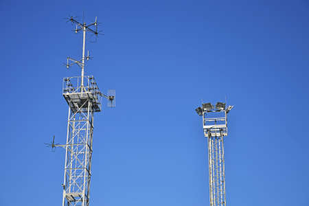 Telecommunication tower with antennas over blue sky.の写真素材