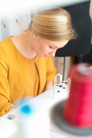 Woman working on sewing machine in the factory.