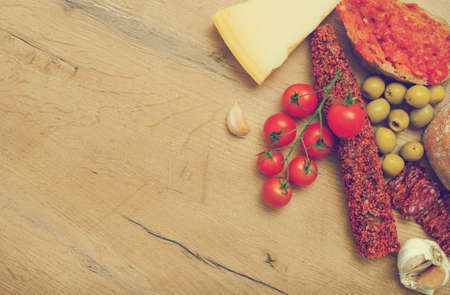 Bruschetta with tomato paste, tomatoes, cheese, olives, garlic and fuet. Place for text. Vintage effect.の写真素材